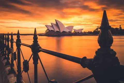 Opernhaus von Sydney bei Sonnenuntergang, gesehen von einem Hafengeländer